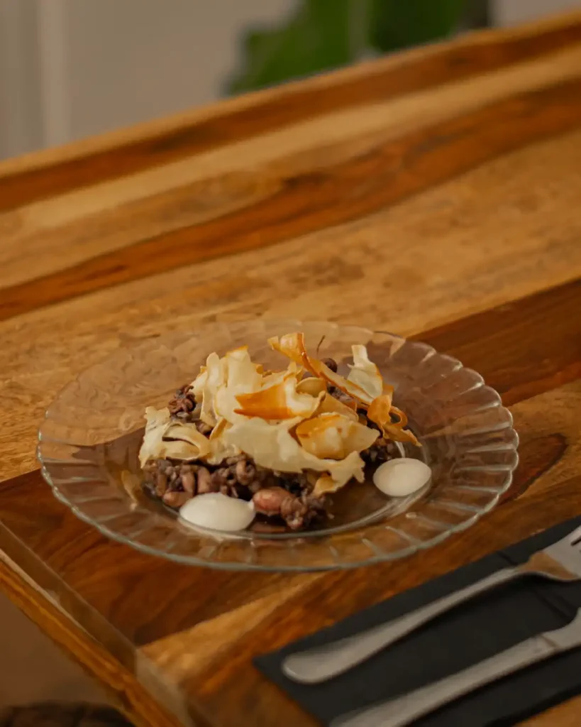 Mini sepias salteadas con su propia tinta, yuca frita y mayonesa de lima
